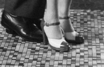 This may contain: a woman's legs in high heels on a tiled floor