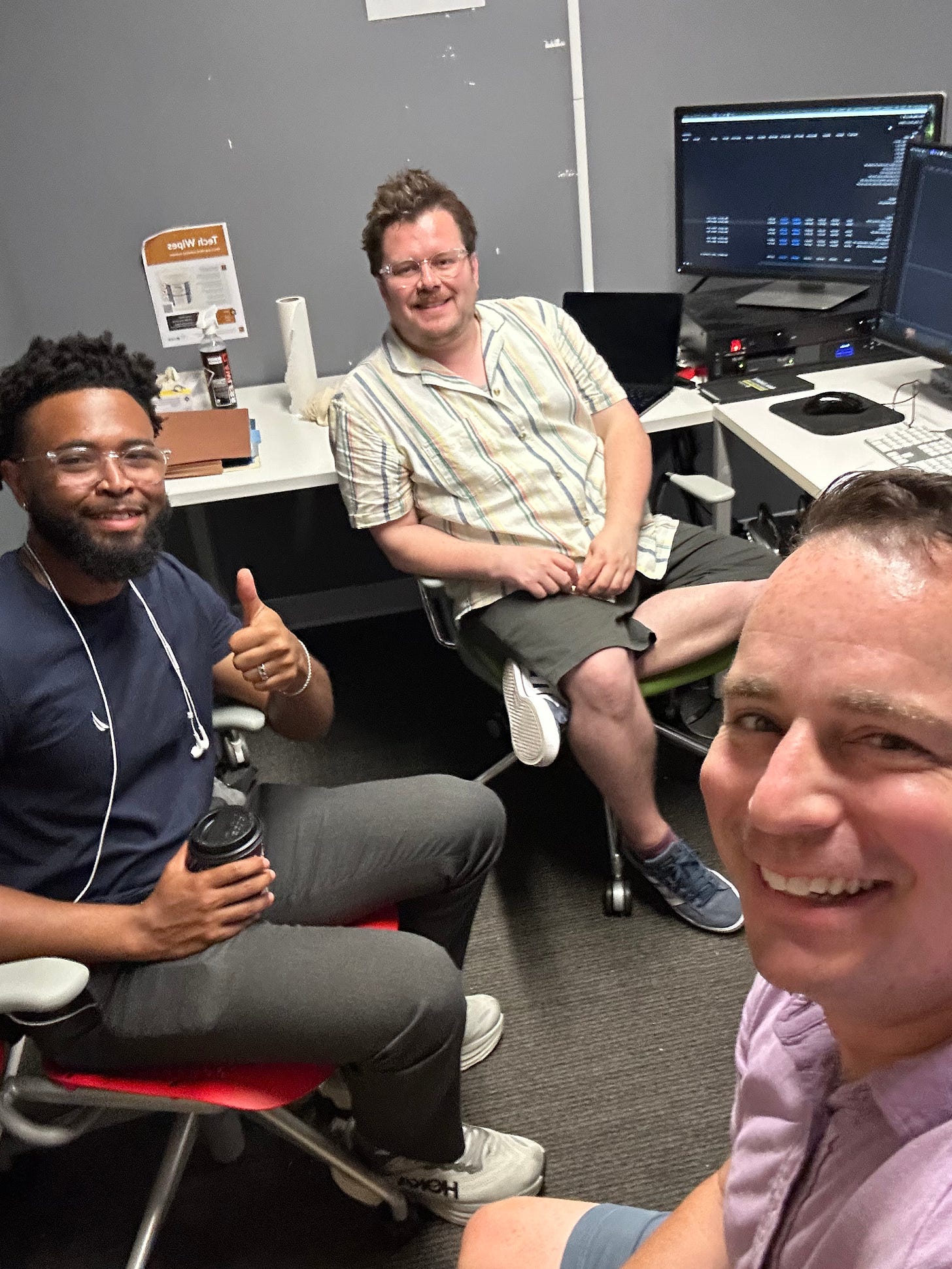 Three men sitting in an edit bay