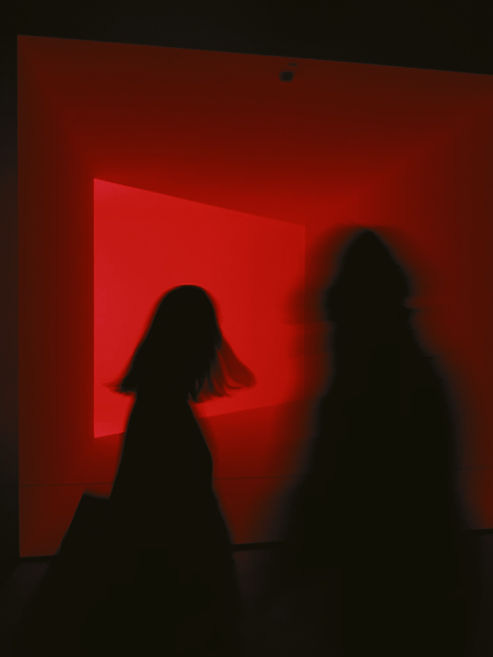 Image of red background with silhouettes of two people. 