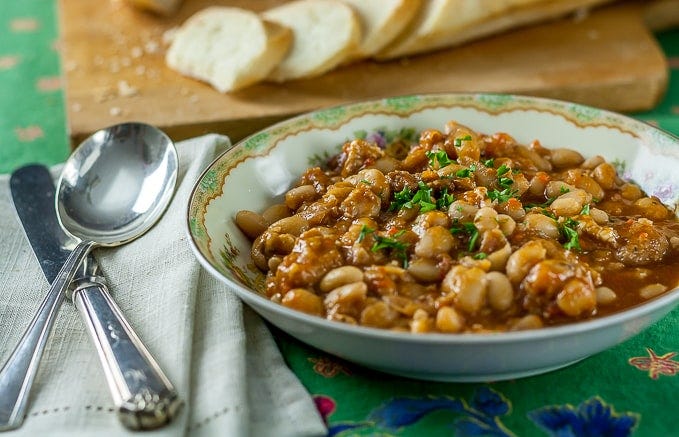 a bowl of french beef stew with a spoon and knife on a napkin on the left a bowl of french beef stew with a spoon and knife on a napkin on the left