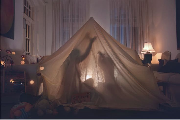 This may contain: a woman is standing in front of a tent with her hands up to the ceiling