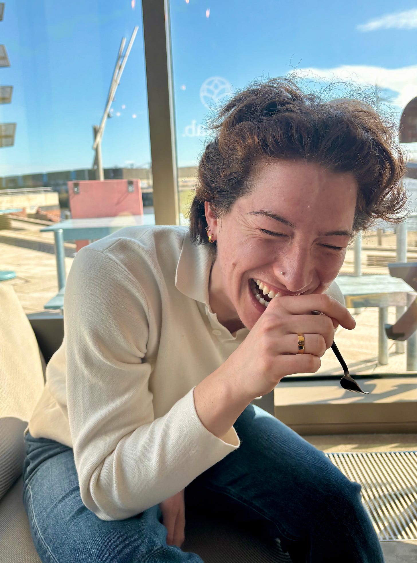 Maeve sits laughing hysterically in the sunshine Maeve sits laughing hysterically in the sunshine