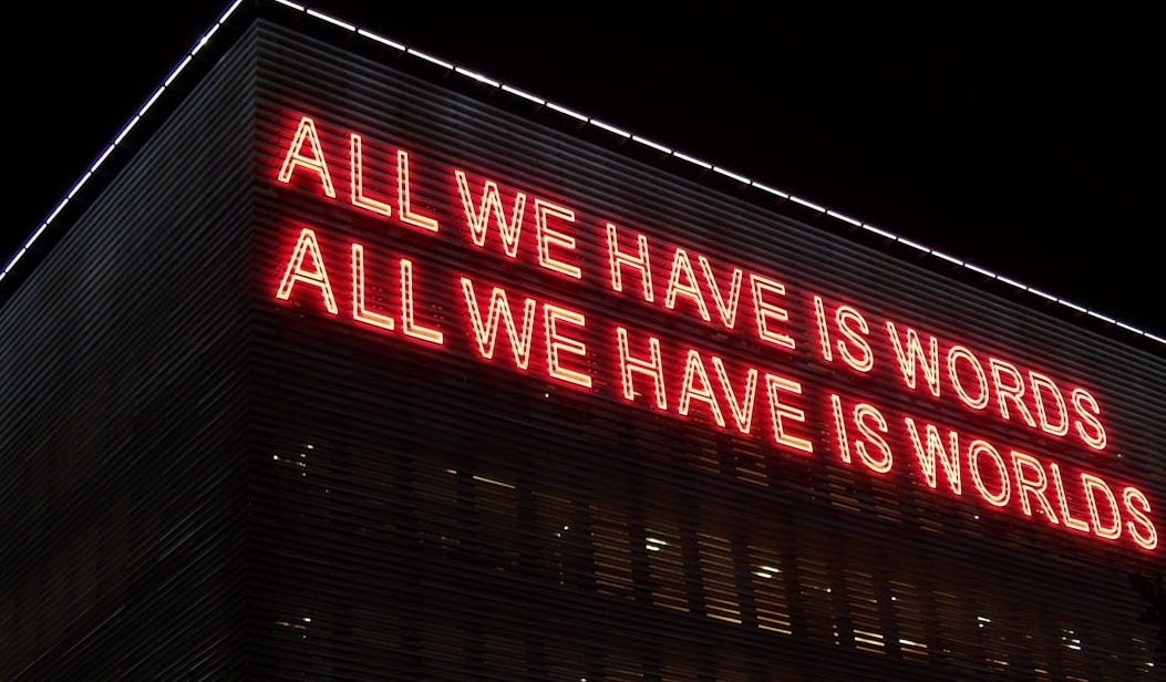 All We Have Is Words All We Have Is Worlds lighted signage at night