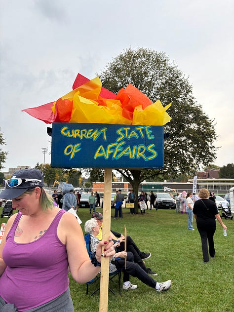 Various protesters and dogs with signs at a NO KINGS rally