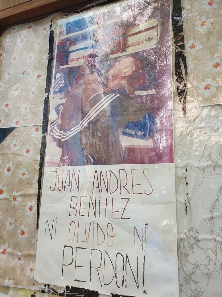 A woman is pointing at a wall with many fotos, next to her are plants and a garden hose. The other image shows a poster with a person cuddling a dog, it says: Juan Andrés Benítez, ni olvido ni perdon.