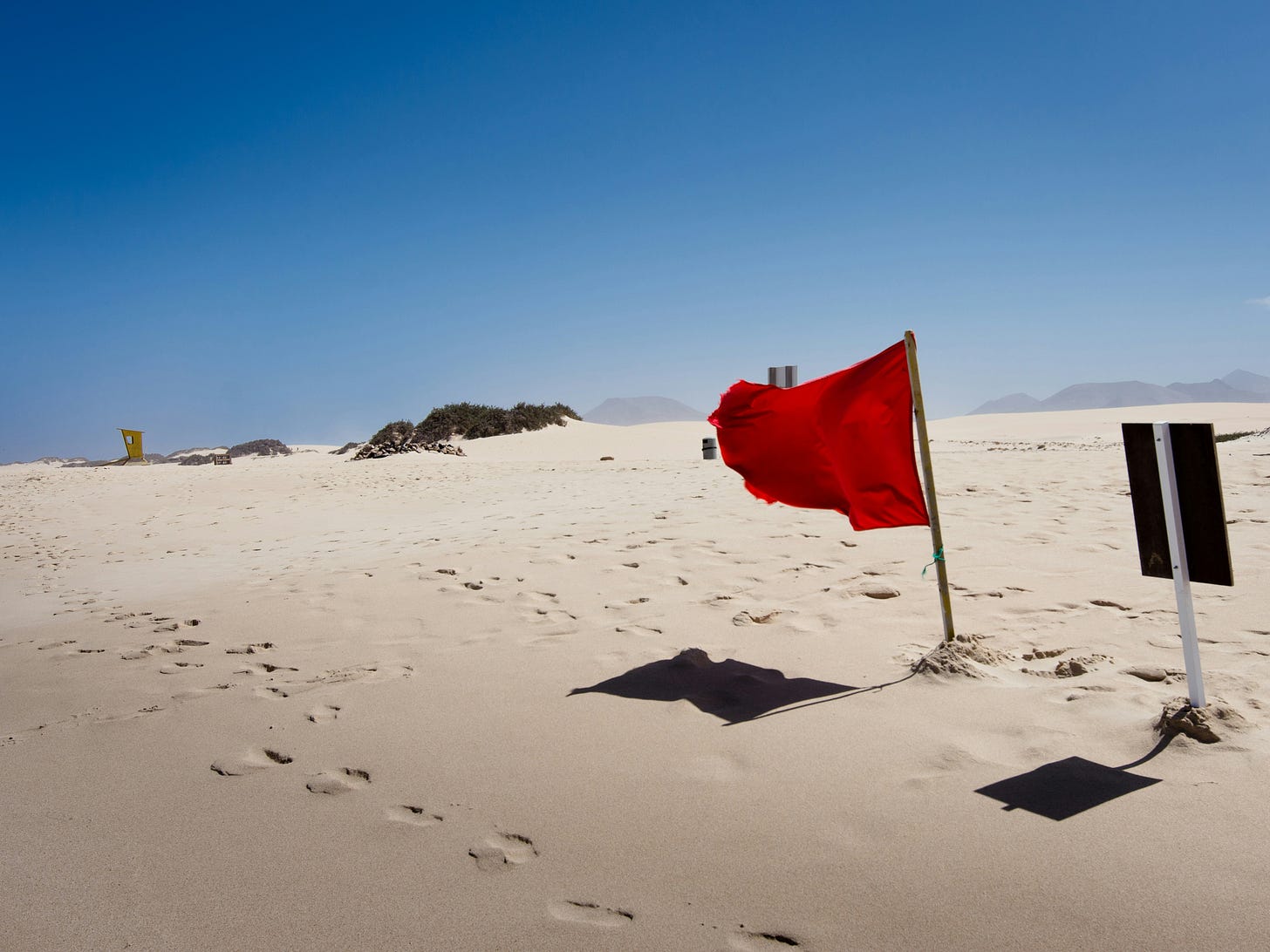 Red flag in the desert with blue sky Red flag in the desert with blue sky