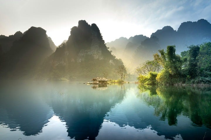 A house on a lake surrounded by mountains

Description automatically generated
