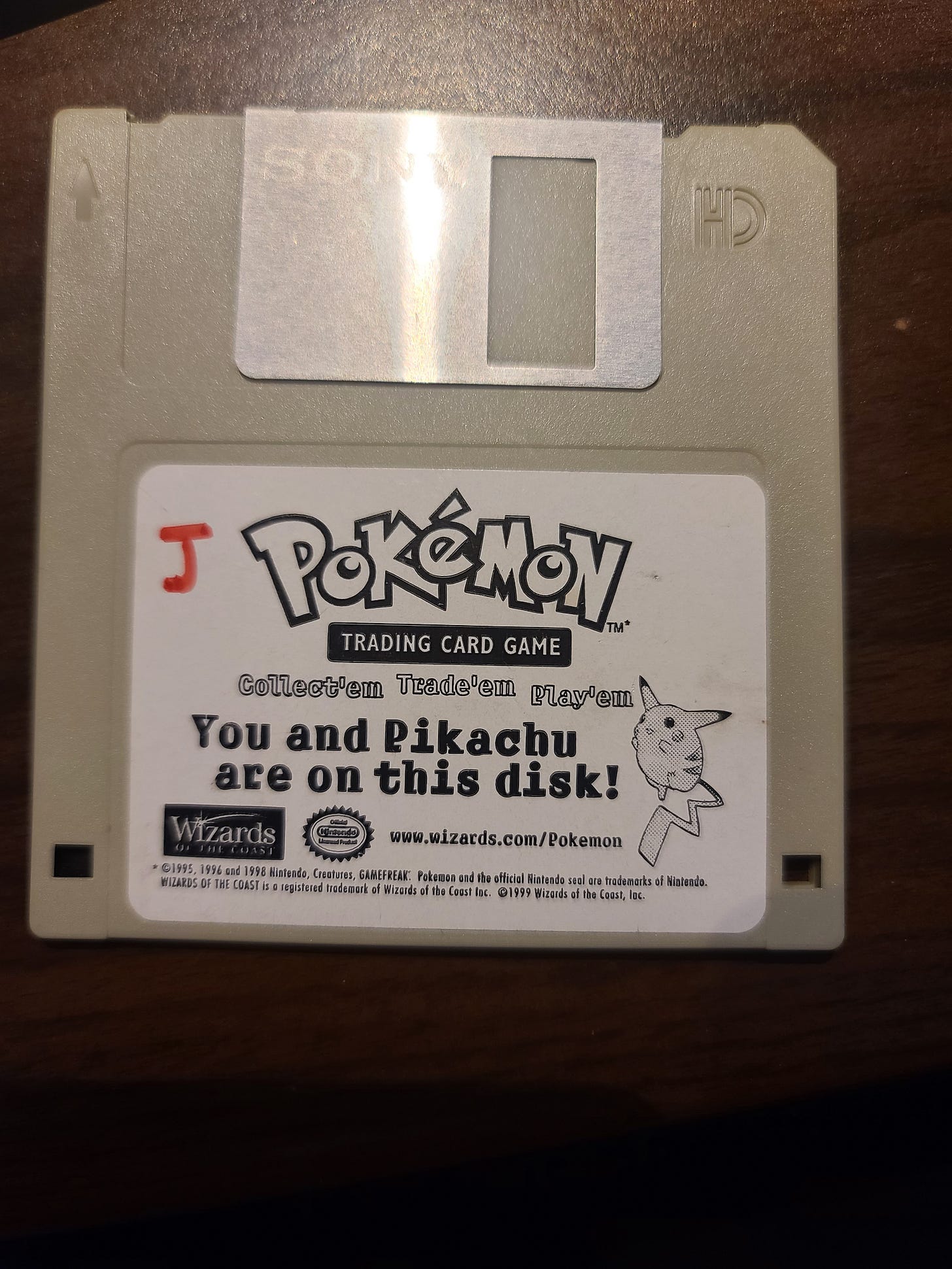 Here is a photograph of the floppy disk that Jim was given, containing a photograph of him standing next to a giant Pikachu card Here is a photograph of the floppy disk that Jim was given, containing a photograph of him standing next to a giant Pikachu card