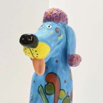 A blue dog statue with a yellow tongue

AI-generated content may be incorrect.