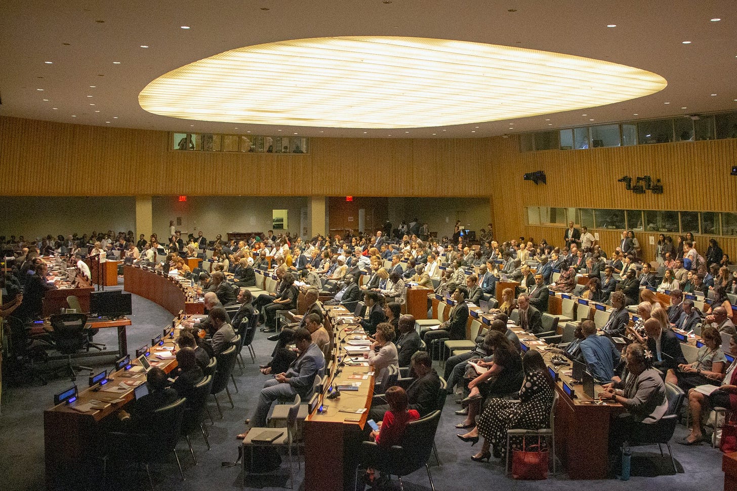 people sitting on chairs inside UN building people sitting on chairs inside UN building