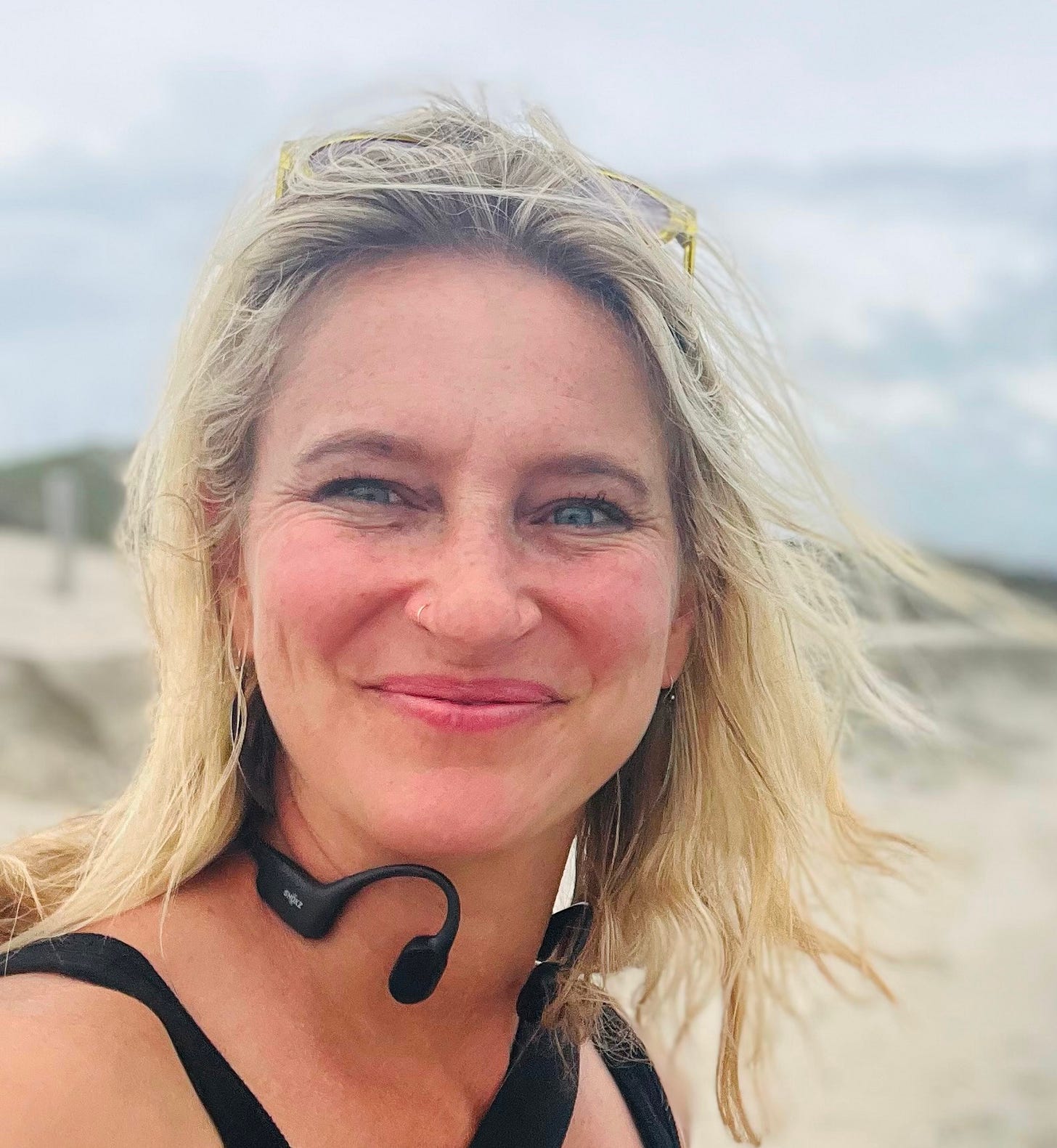 white woman with short blond hair and blue eyes on a beach