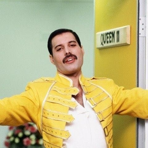 a man in a yellow jacket with his arms out and one hand on the door