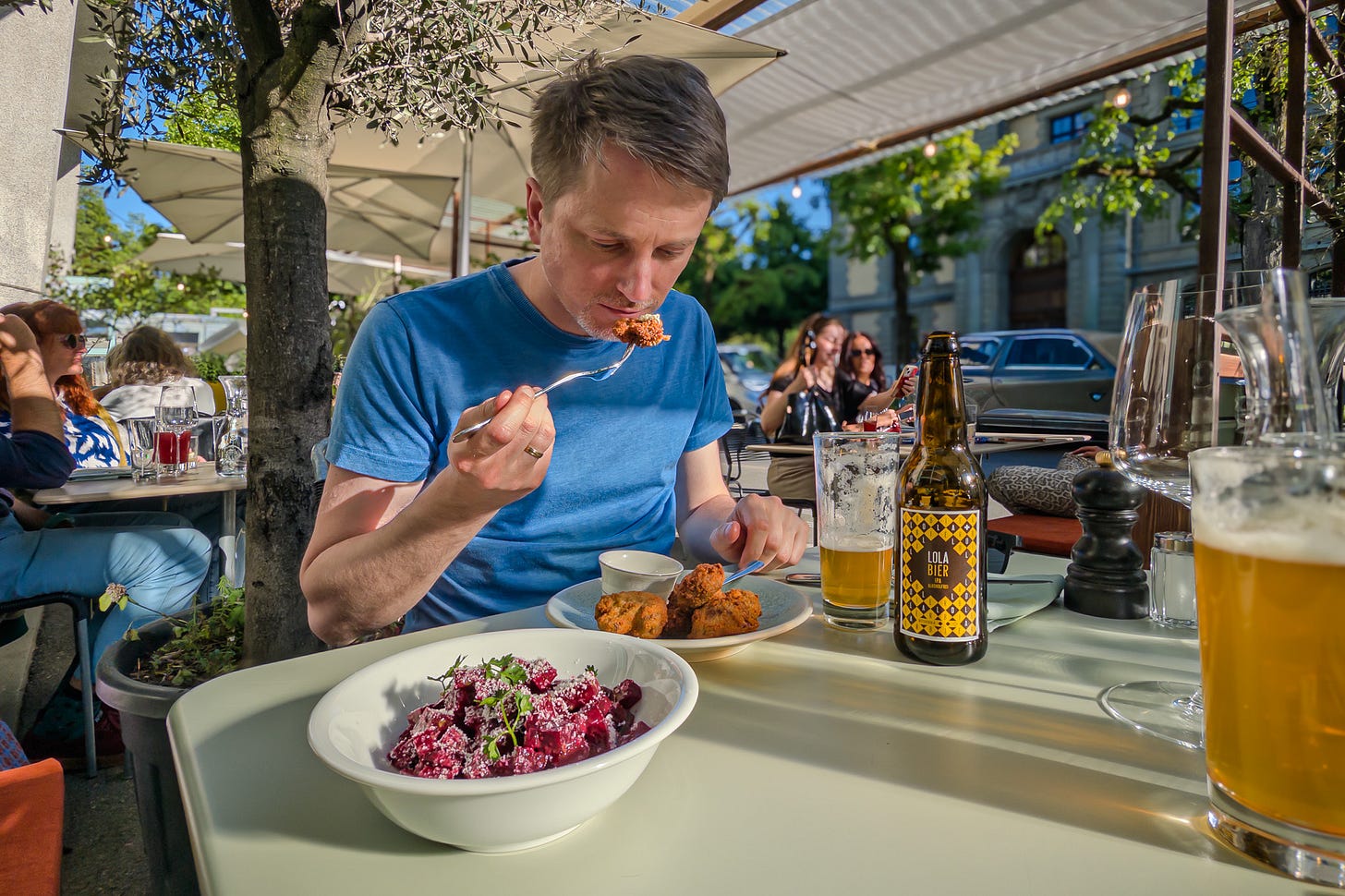 Der Biologe Martin Reich sitzt an einem Tisch im Restaurant «Löscher» in Bern und probiert eine Vorspeise mit einer Gabel. Vor ihm stehen eine Schüssel mit Roter Bete, ein Teller mit frittierten Champignons sowie eine Flaschen lokales «Lola»-Bier. Die Szene spielt auf der sonnigen Terrasse unter Bäumen und Sonnenschirmen. Der Biologe Martin Reich sitzt an einem Tisch im Restaurant «Löscher» in Bern und probiert eine Vorspeise mit einer Gabel. Vor ihm stehen eine Schüssel mit Roter Bete, ein Teller mit frittierten Champignons sowie eine Flaschen lokales «Lola»-Bier. Die Szene spielt auf der sonnigen Terrasse unter Bäumen und Sonnenschirmen.
