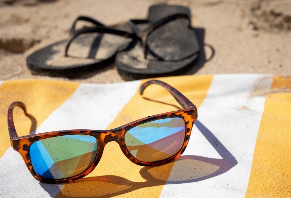 black framed sunglasses on white and brown textile black framed sunglasses on white and brown textile