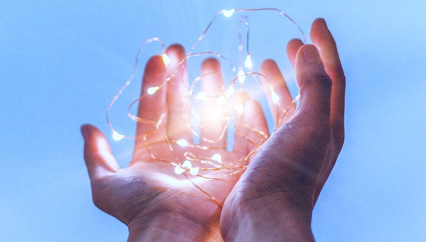 Mans hands holding connected lights glowing