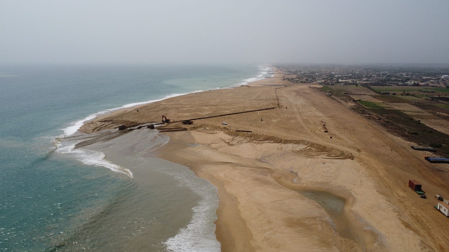 An aerial shot shows the shape of a 'sand motor' project in Benin. The project was built by the dredging firm Boskalis with funding from a World Bank erosion initiative. An aerial shot shows the shape of a 'sand motor' project in Benin. The project was built by the dredging firm Boskalis with funding from a World Bank erosion initiative.