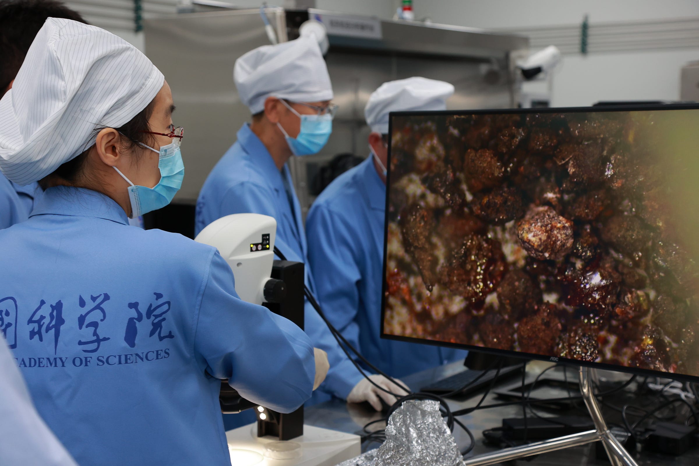 Scientists analyze some samples collected by Chang’e 6 under a microscope. Scientists analyze some samples collected by Chang’e 6 under a microscope.