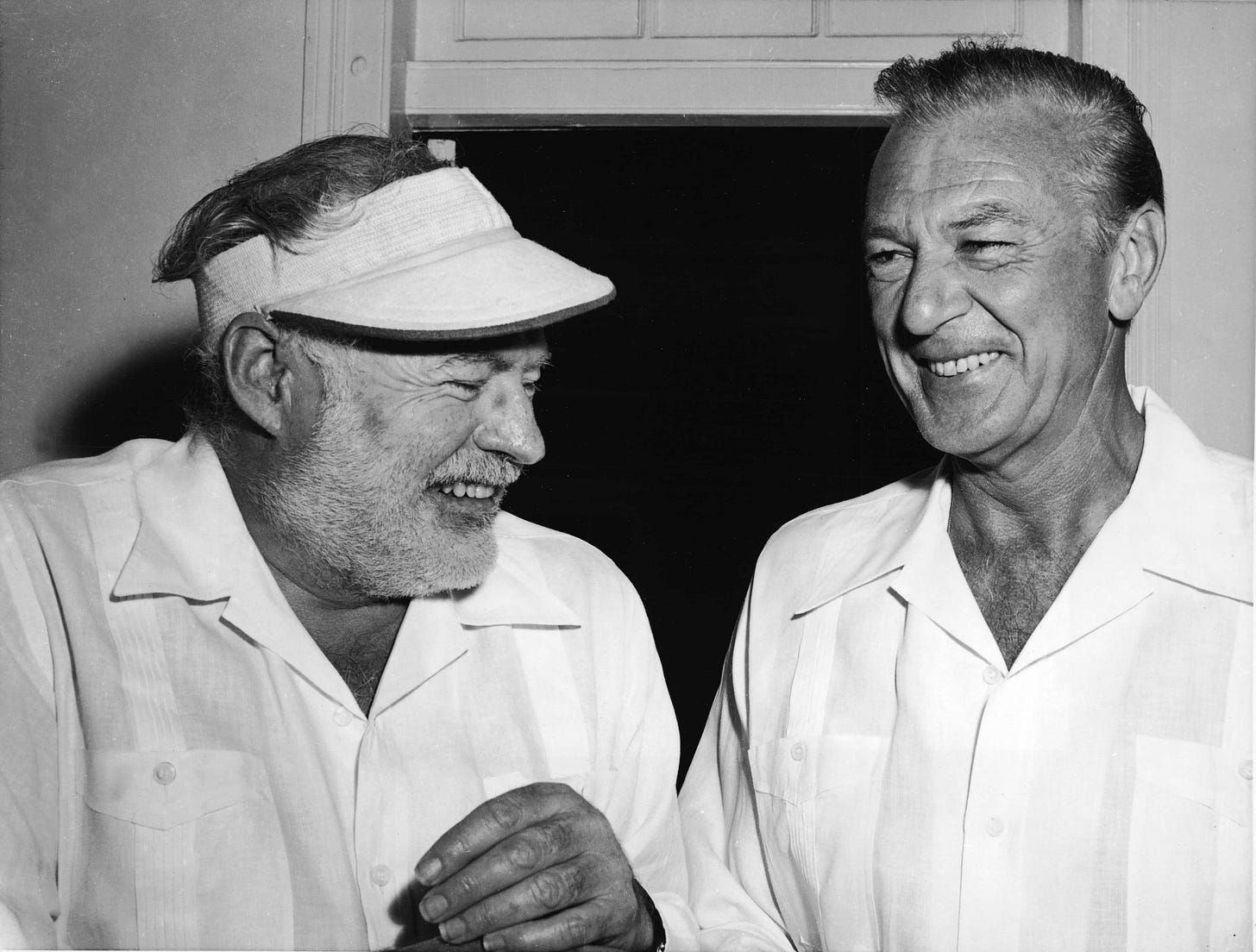 Literary icon Ernest Hemingway sharing a moment with Hollywood legend Gary Cooper in the 1950s.