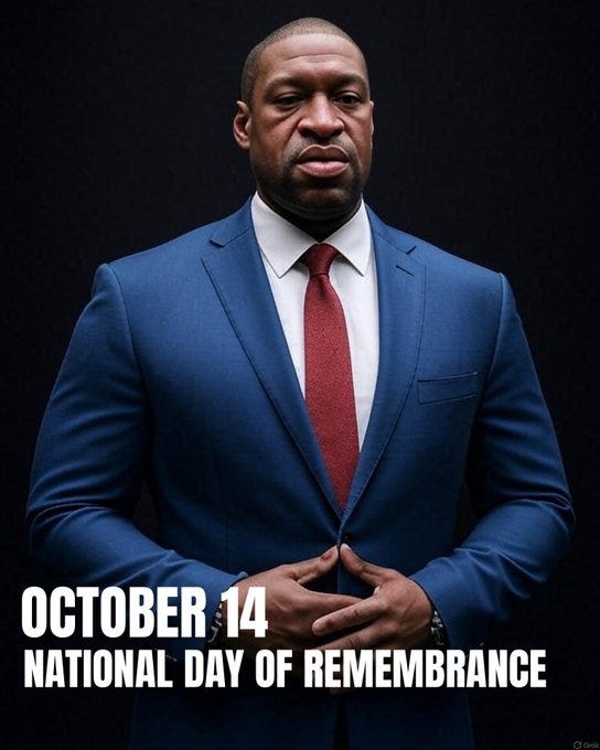 A middle-aged Black man with a serious expression stands formally against a black background, wearing a blue suit jacket, white dress shirt, and red tie, hands clasped in front at waist level. White text overlay at the bottom reads October 14 National Day of Remembrance.