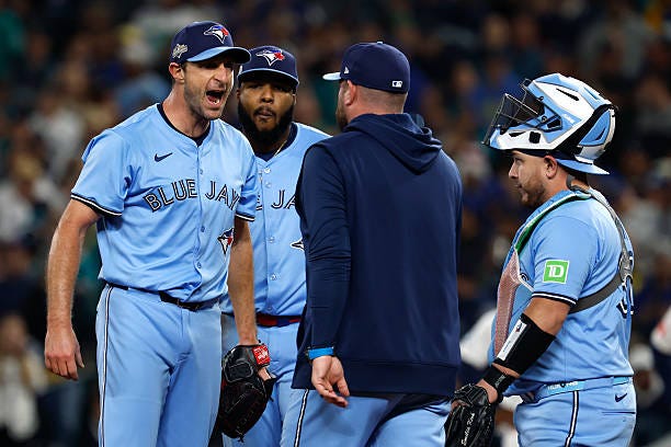 Manager John Schneider of the Toronto Blue Jays walks to the mound to talk to Max Scherzer during the fifth inning against the Seattle Mariners in...