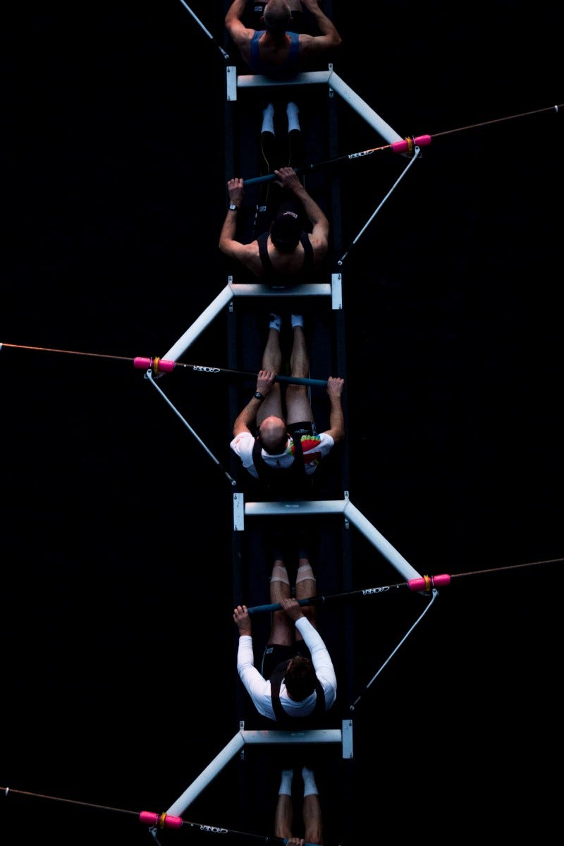 Image of five people rowing a boat together. Image of five people rowing a boat together.
