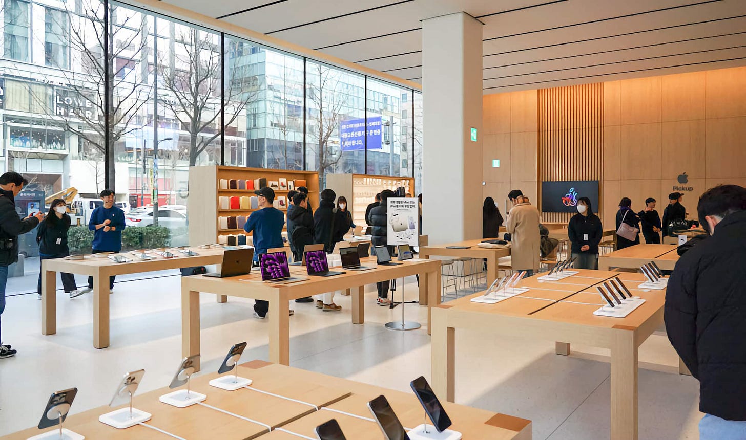 Product tables, freestanding Avenues, and large glass windows fill Apple Hongdae. Product tables, freestanding Avenues, and large glass windows fill Apple Hongdae.
