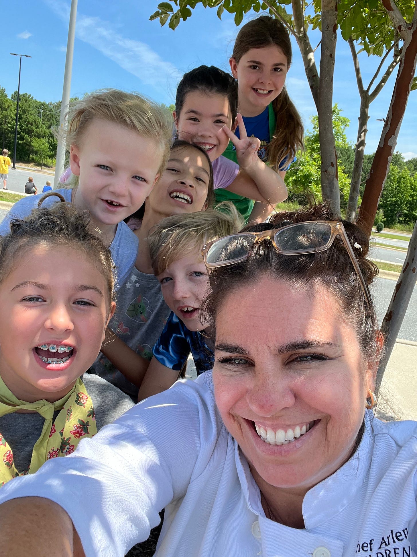 smiling chef taking a selfie with 6 happy children