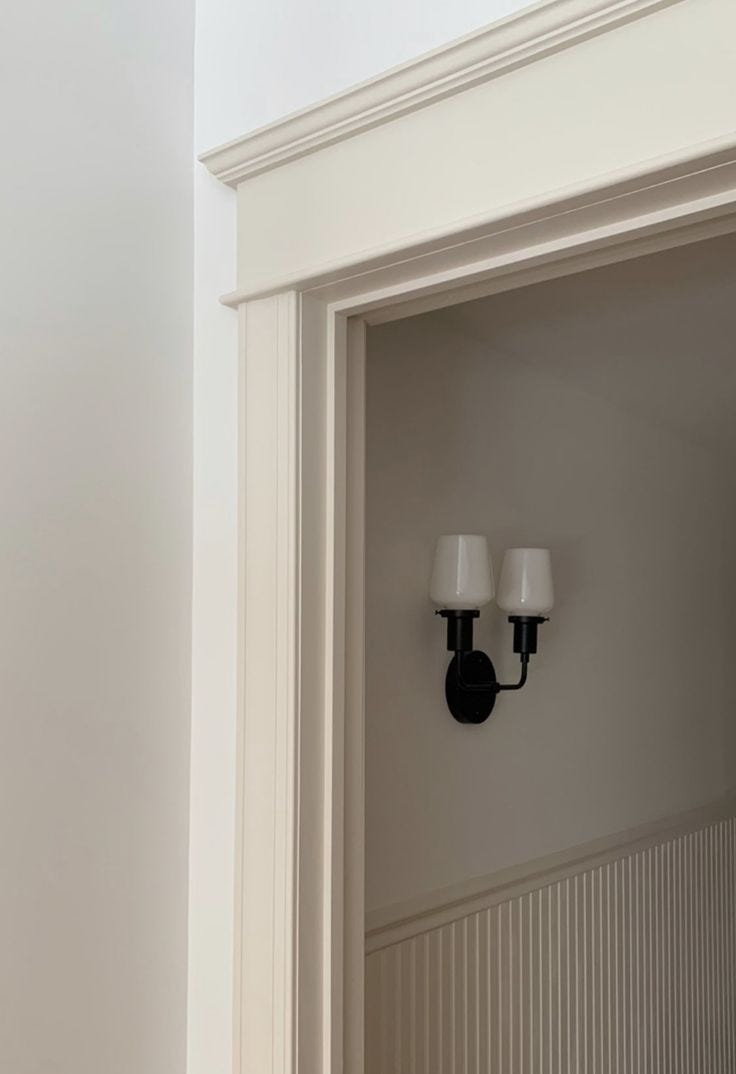 This may contain: an open door with two lights on each side and a white wall in the background
