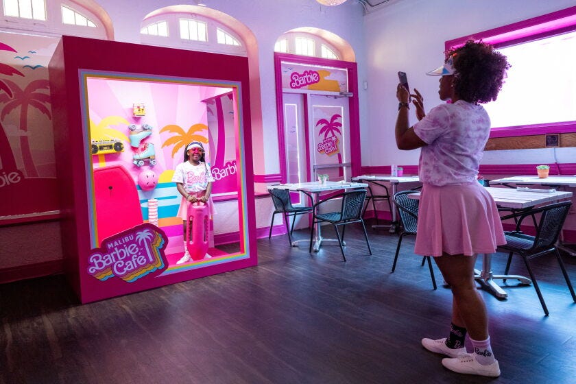 Keona Philemy takes a photo of her daughter Elleona Philemy, 10, in one of the many selfie areas (this one lets you to be your own Barbie in a toy box), at the Malibu Barbie Cafe pop-up.