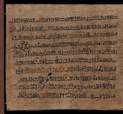 A mid-brown papyrus with lines of hieratic script in black ink. 