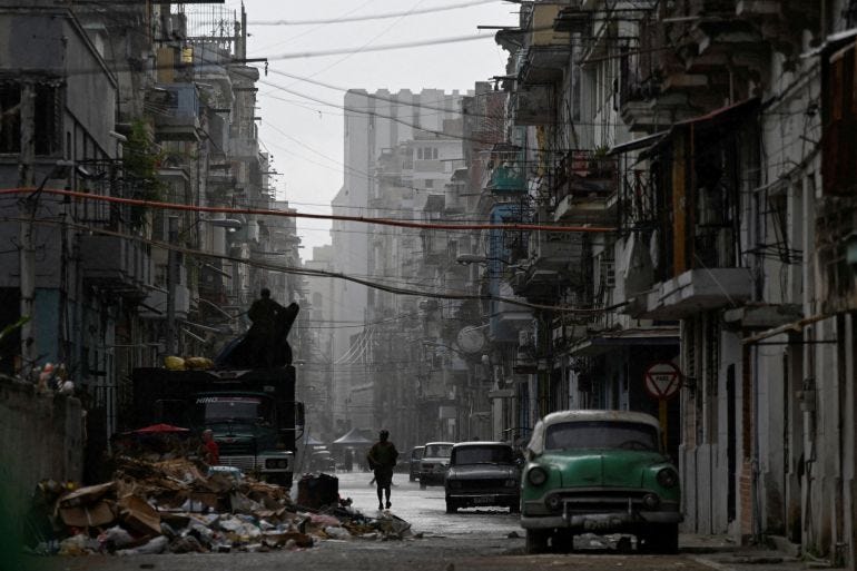 A man walks on a street in the rain as Cuba reconnected its electrical grid across much of the island A man walks on a street in the rain as Cuba reconnected its electrical grid across much of the island