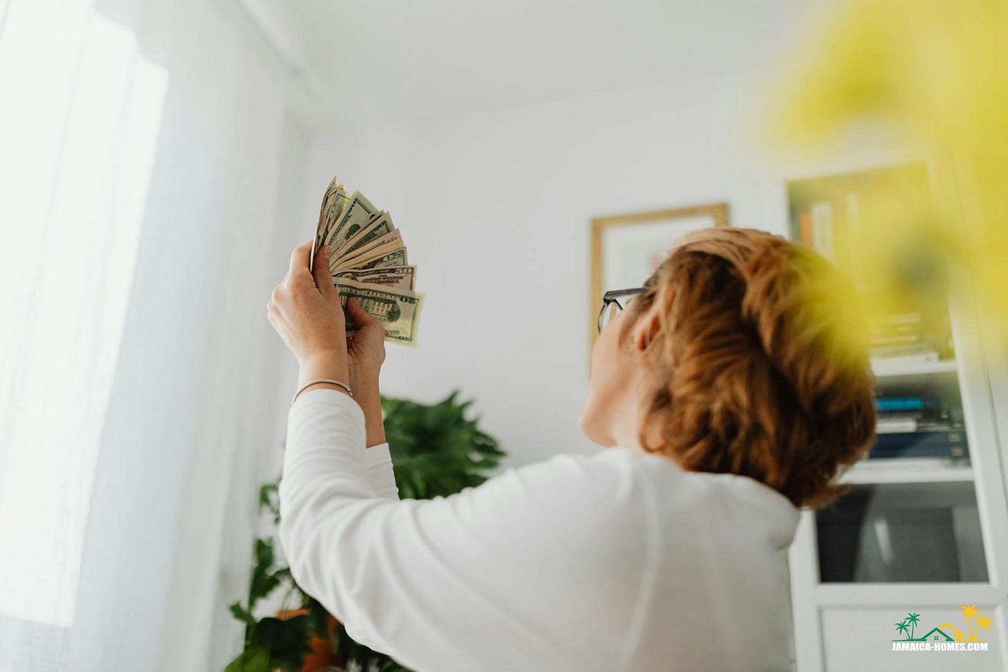 person in white long sleeve shirt holding dollar bills