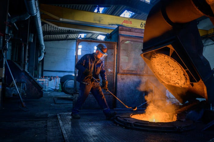 A worker pours a copper alloy bar in a melting furnace at a tube plant.