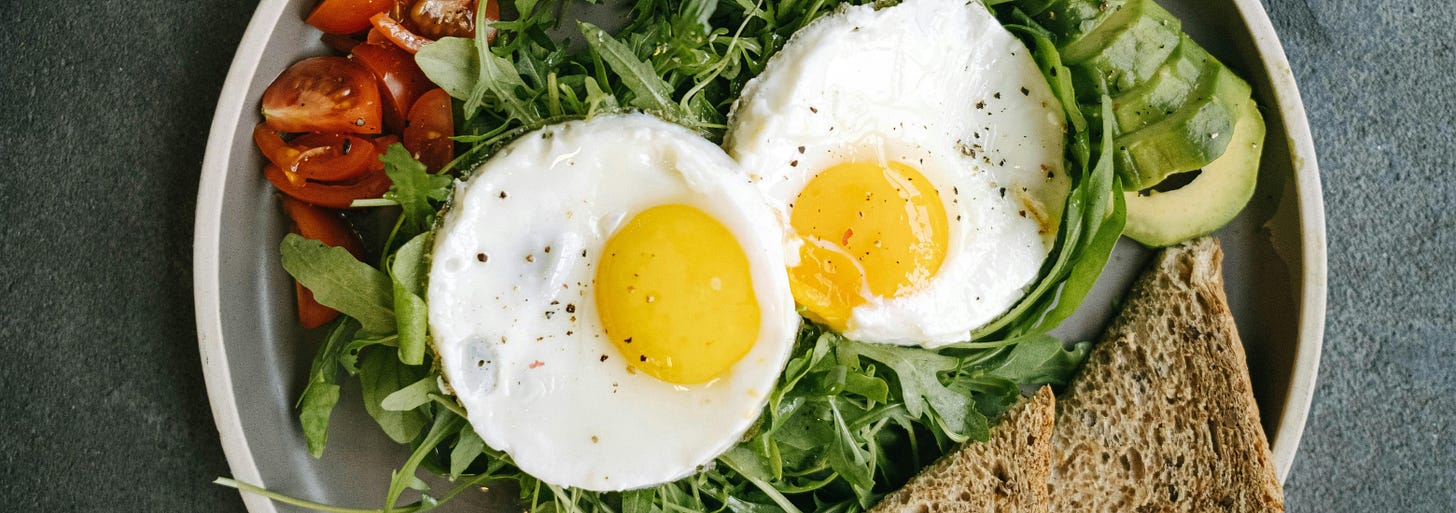 Plate with greens, eggs and brown bread