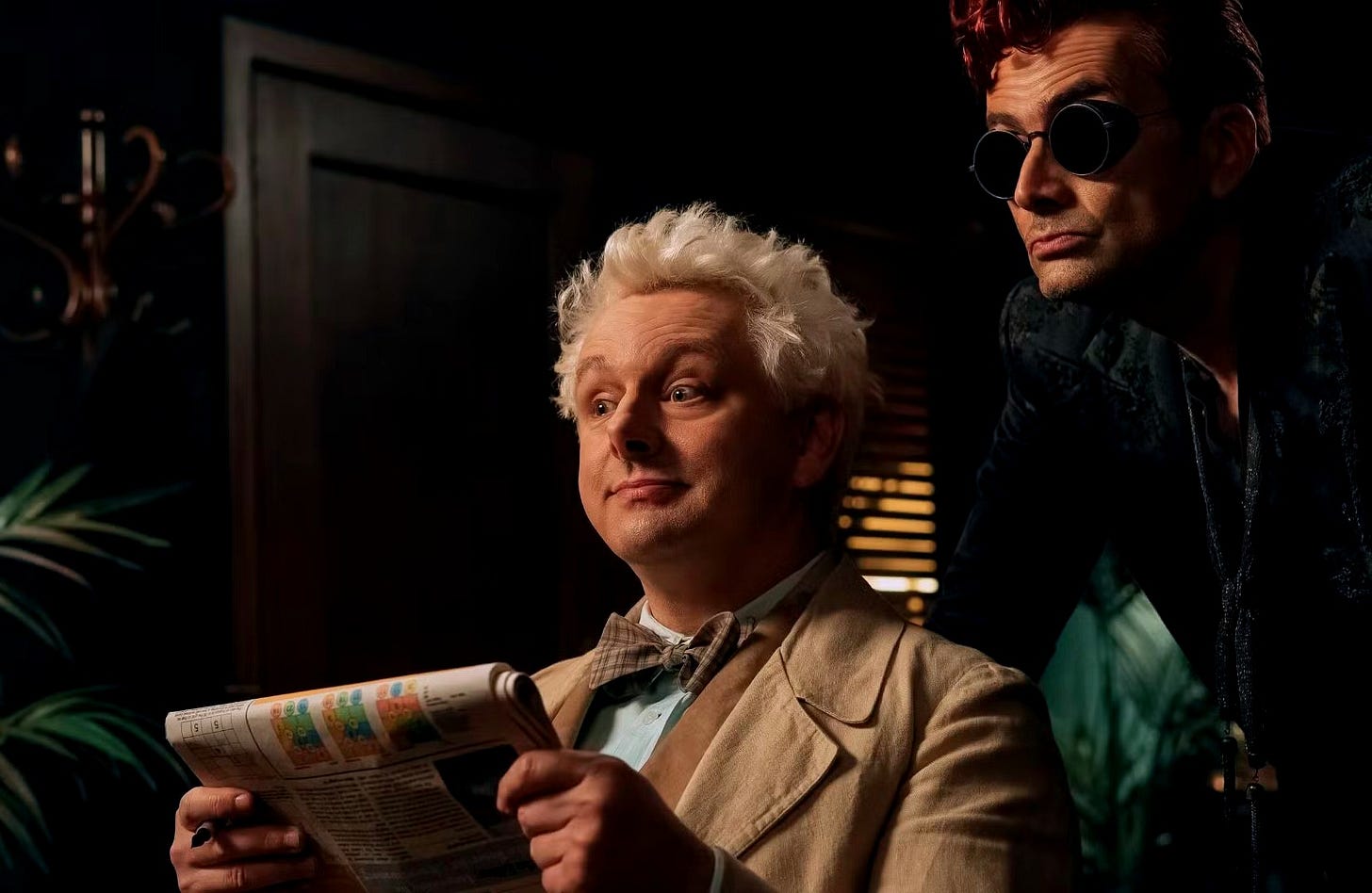 Aziraphale (Michael Sheen) and Crowley (David Tennant) prepare to win back Crowley’s car in a game of…crossword puzzles. (Credit: Prime Video)