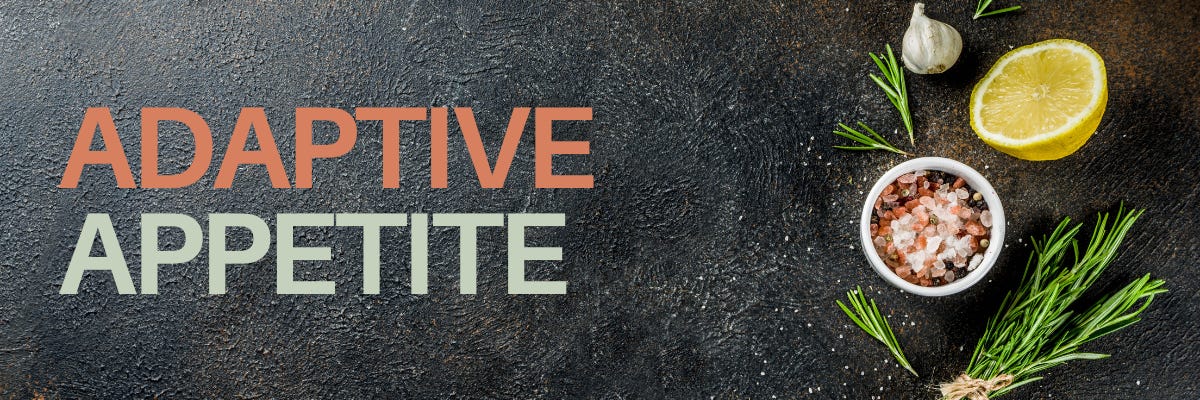 Adaptive Appetite on a black slate with garlic, lemon, salt and herbs showing.