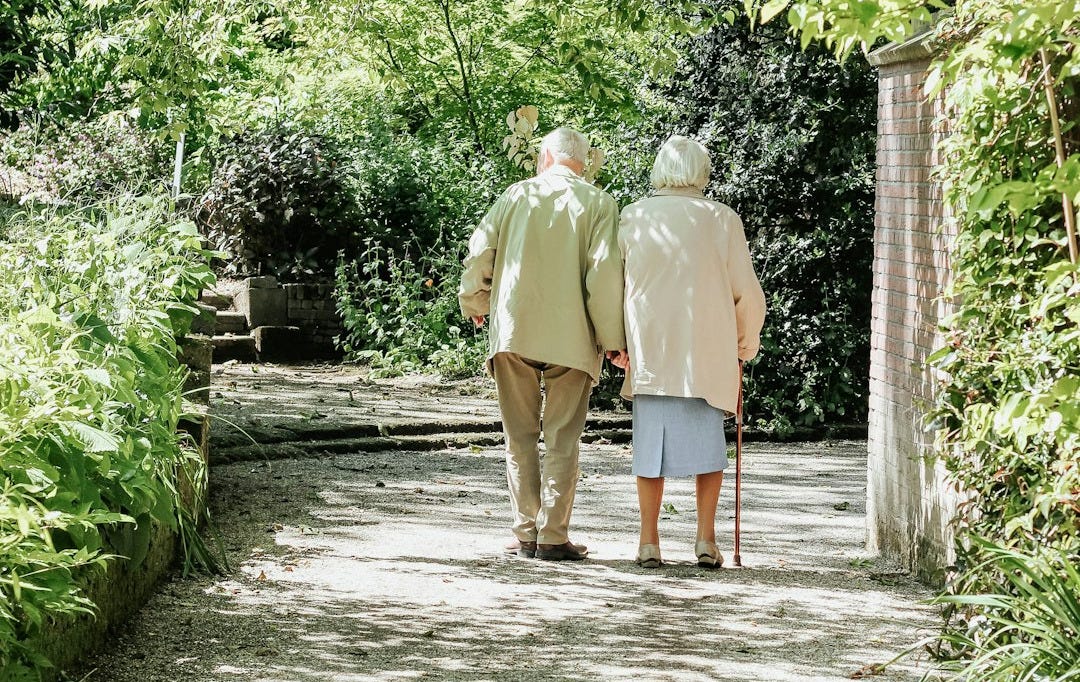 man and woman walking on road during daytime man and woman walking on road during daytime