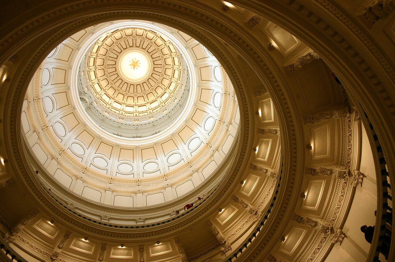 Looking upward inside the Texas Capitol toward a star on top of the dome