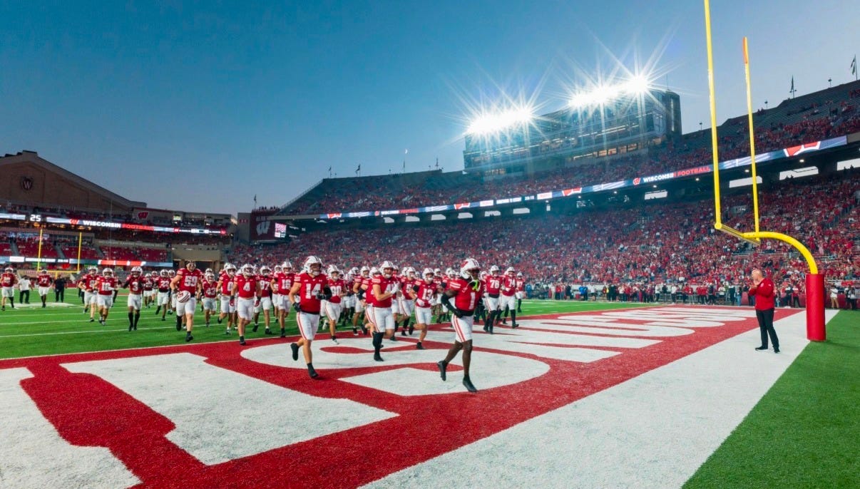 Wisconsin Badgers football players running off the field at Camp Randall Stadium.