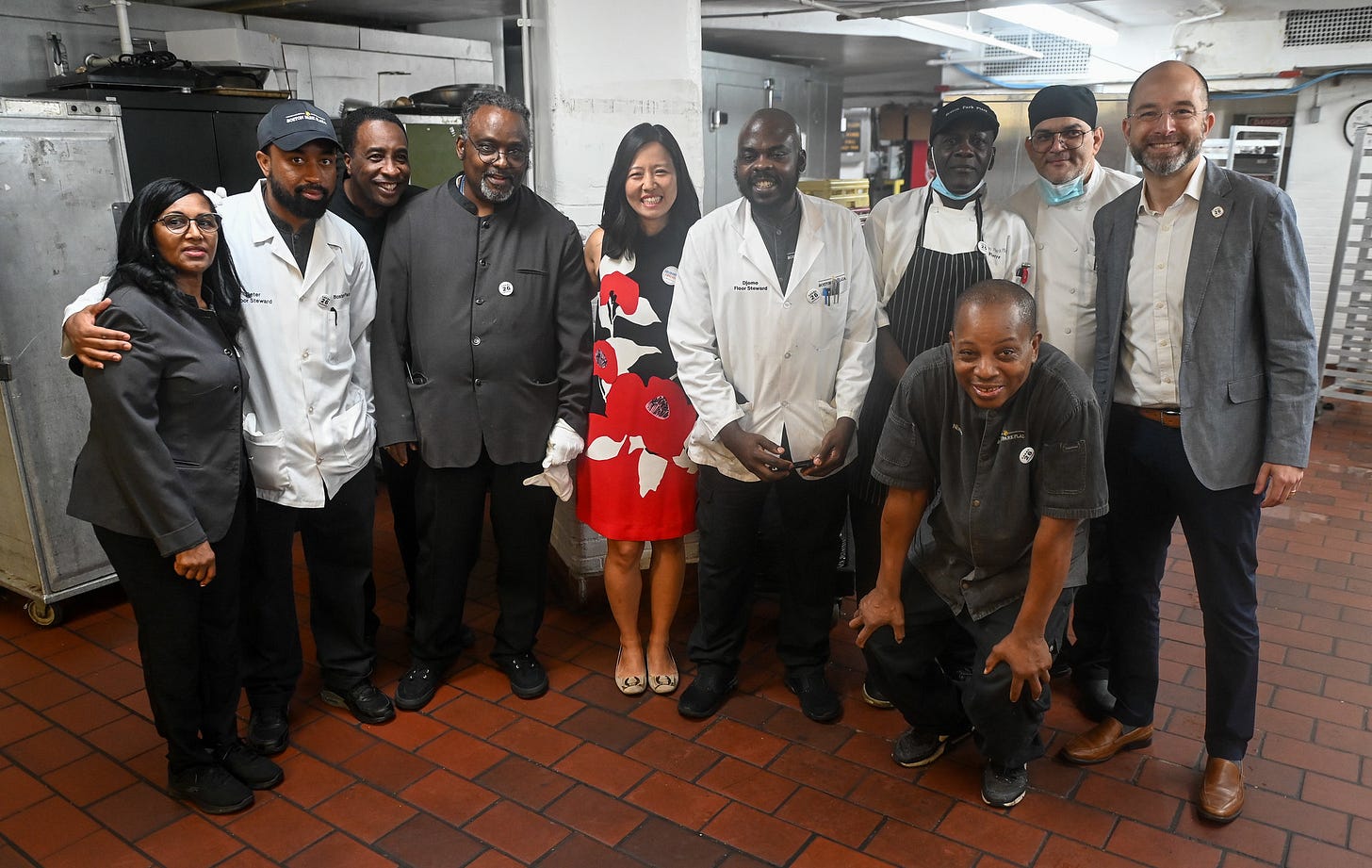 Michelle smiles for a photo with workers in the kitchen before the event Michelle smiles for a photo with workers in the kitchen before the event