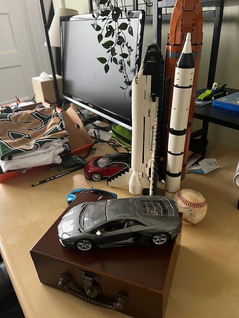 A desk filled with toy cars, legos, etc.