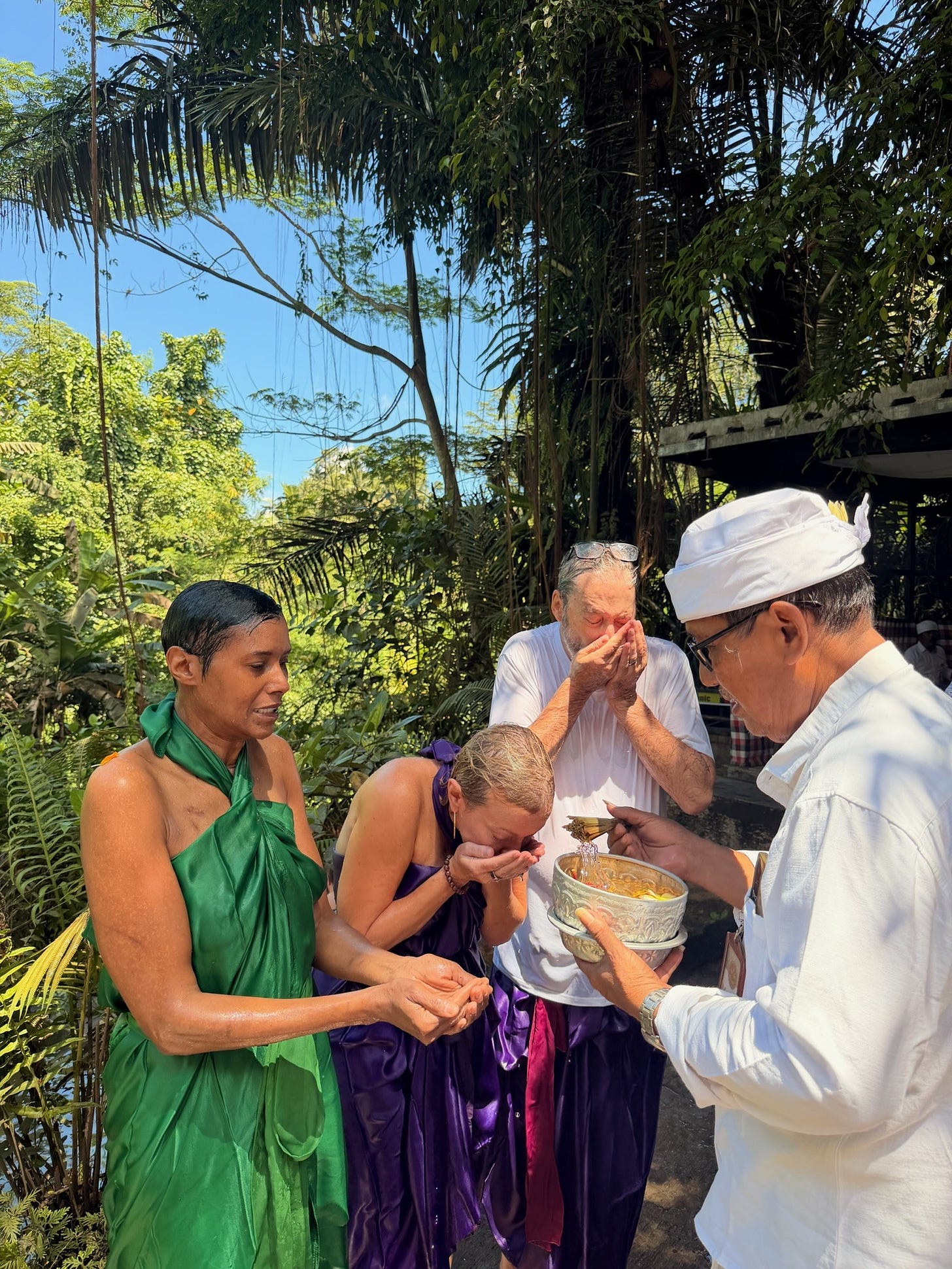 Waterfall cleansing ceremony at Melikat in Bali with flowing water, stone carvings, and ritual activity. Waterfall cleansing ceremony at Melikat in Bali with flowing water, stone carvings, and ritual activity.