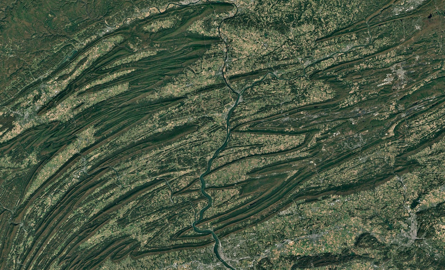 aerial imagery showing lots of bent, long, parallel mountains