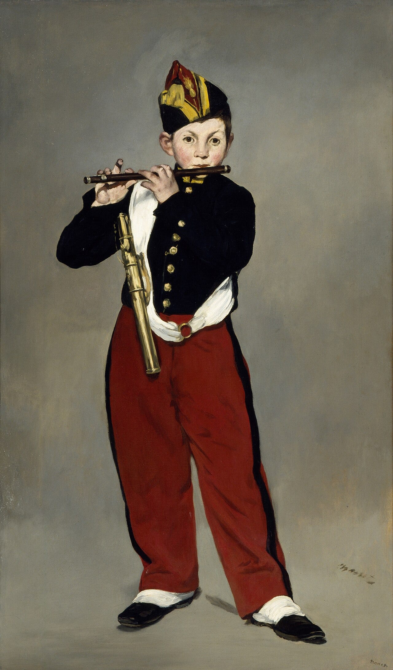 Young boy in a military uniform playing a fife against a plain background Young boy in a military uniform playing a fife against a plain background