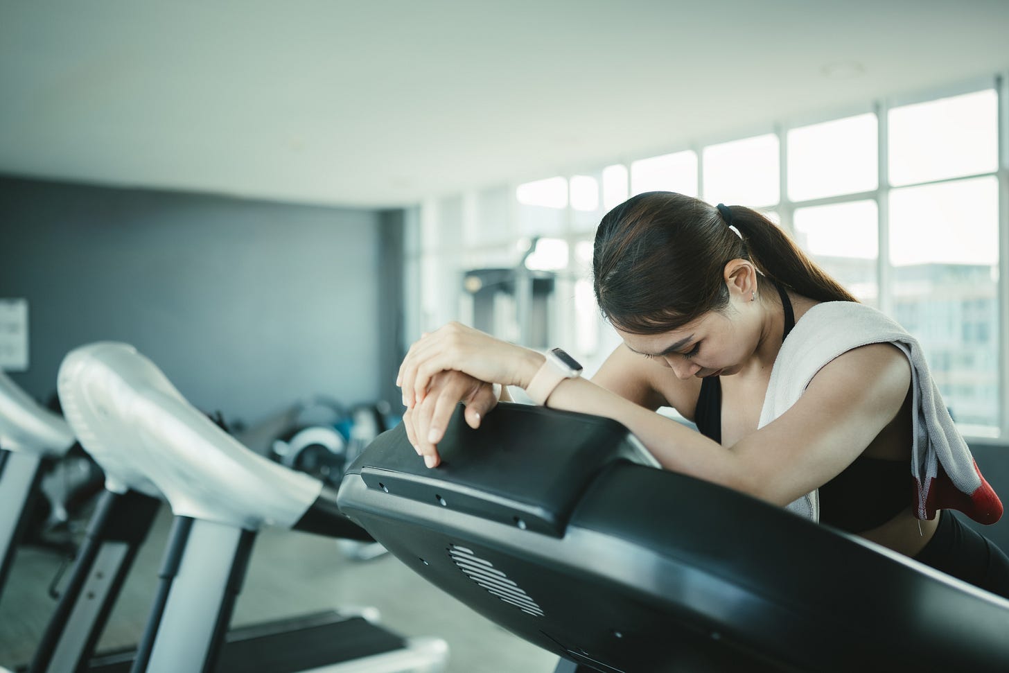Woman on a treadmill leaning over as though exhausted. Woman on a treadmill leaning over as though exhausted.