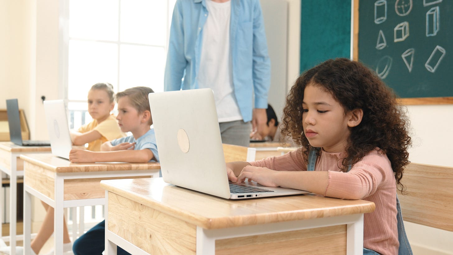 1st graders looking at laptops in a classroom 1st graders looking at laptops in a classroom