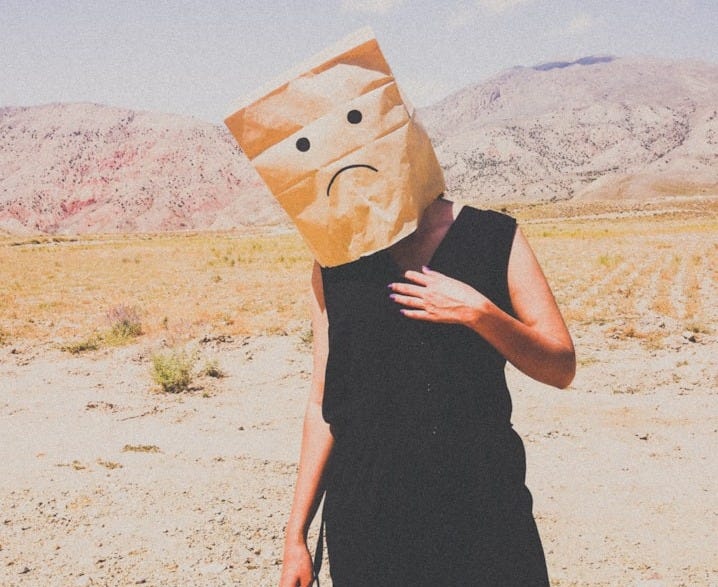 woman in black dress holding brown paper bag woman in black dress holding brown paper bag