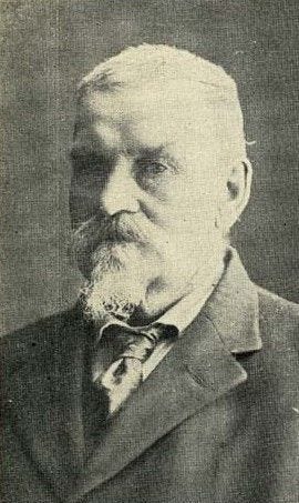 A person with a beard and mustache

Description automatically generated
