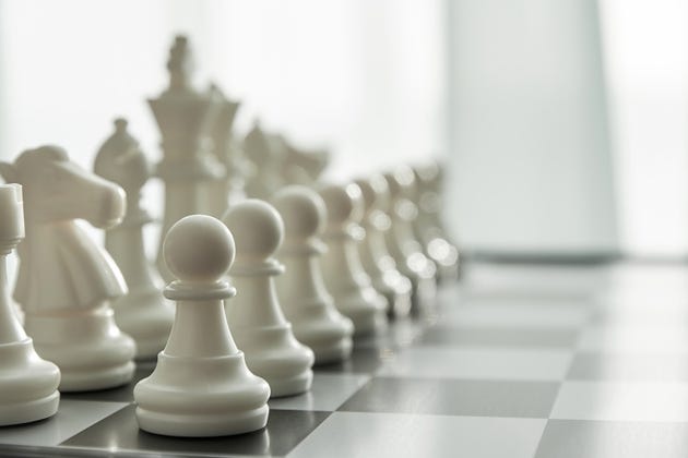 White Chess figures in a row on the board with blurred perspective view White Chess figures in a row on the board with blurred perspective view