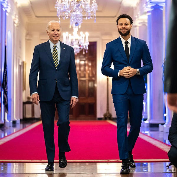 President Biden and Steph Curry walk side-by-side.